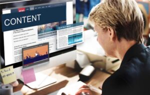 Person working on a desktop computer displaying content marketing strategies, emphasizing digital marketing and website design.